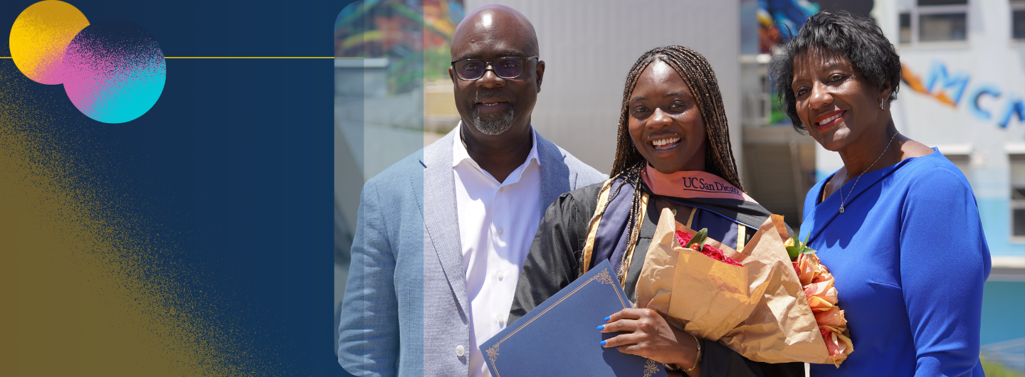 Image of a student with their family standing for a picture at commencement. The graduate is holding flowers and a diploma